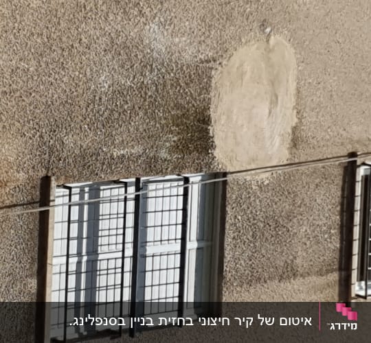 קיר בניין עם חלון וסורגים